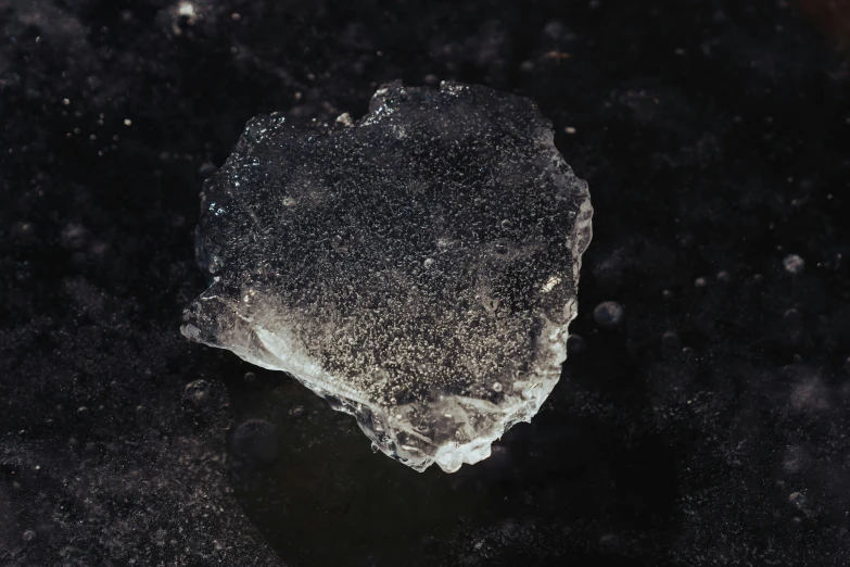 a piece of rock sitting on top of a black surface