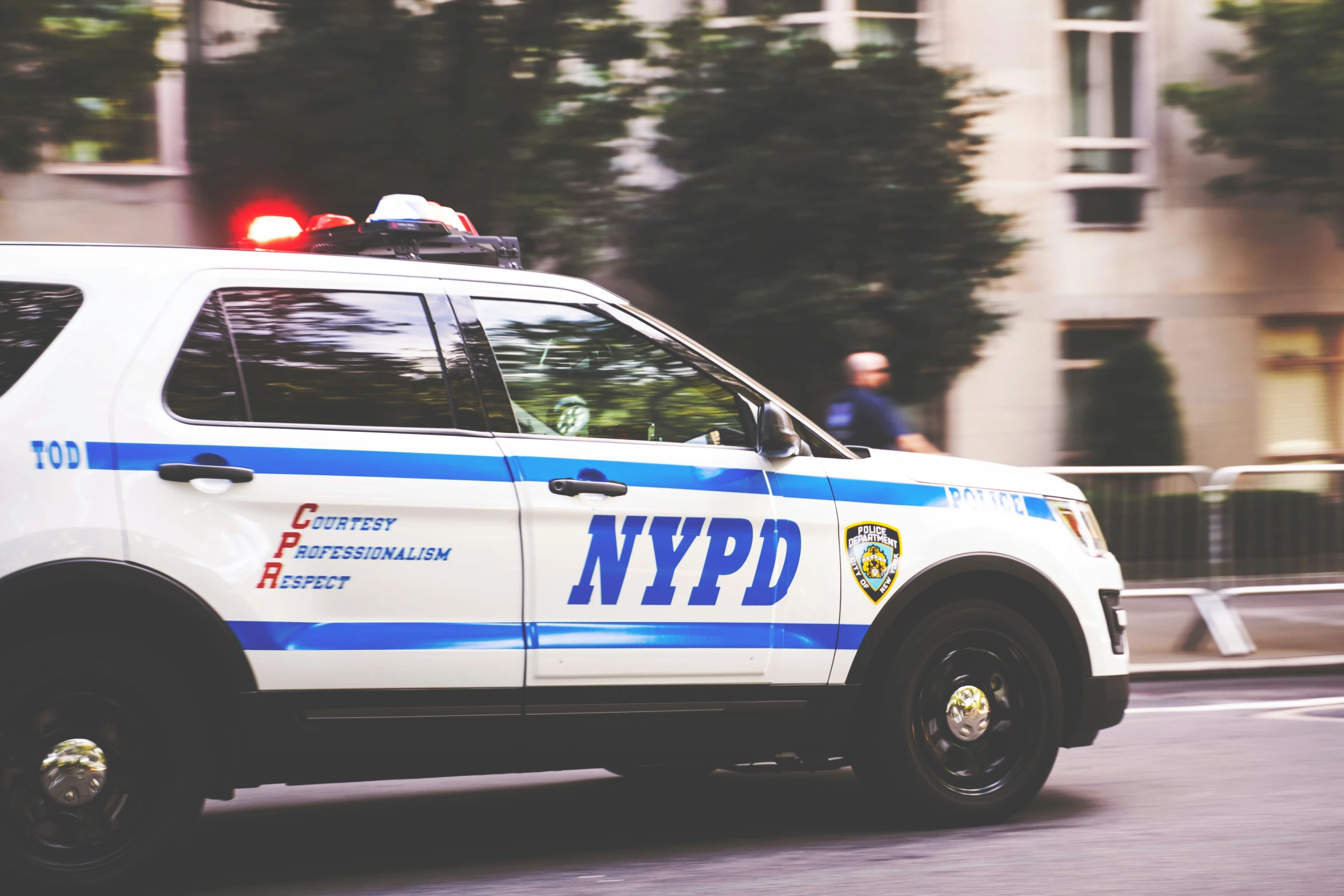 a blue and white police car is going down the road