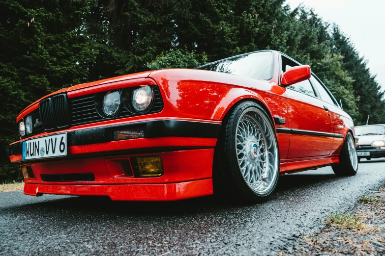 a red sports car is parked by some trees