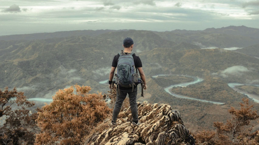 a person with a backpack standing on top of a mountain