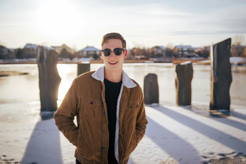 a young man poses in front of a dock