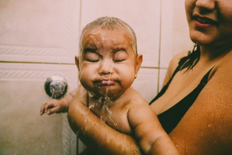 a woman is looking at her face in the shower