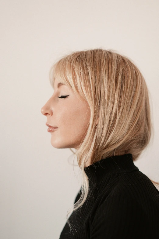 a woman in black shirt standing next to a wall