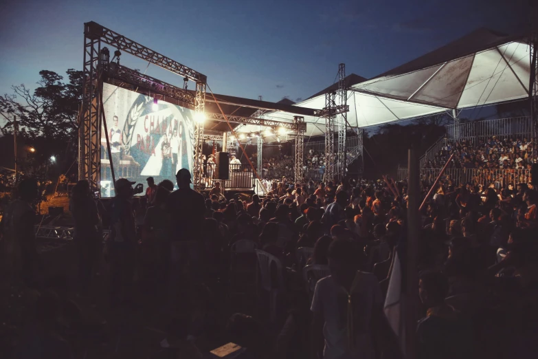 people in the evening standing at a stage