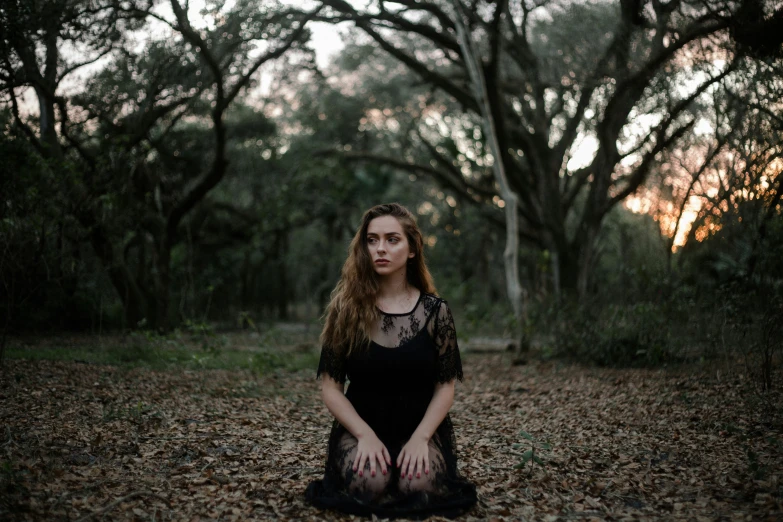 a woman in black sitting on the ground