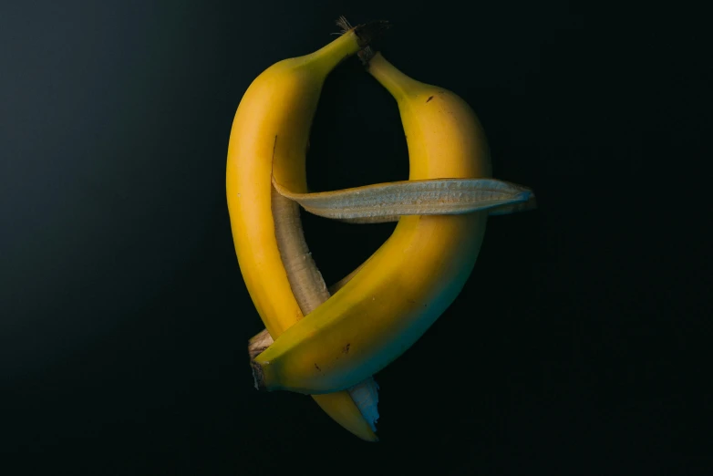 two bananas with an unusual shape hanging from a hook