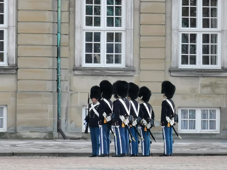 a group of people with uniforms standing on the street