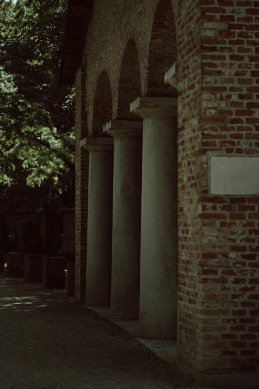 a building with columns in the background and trees growing