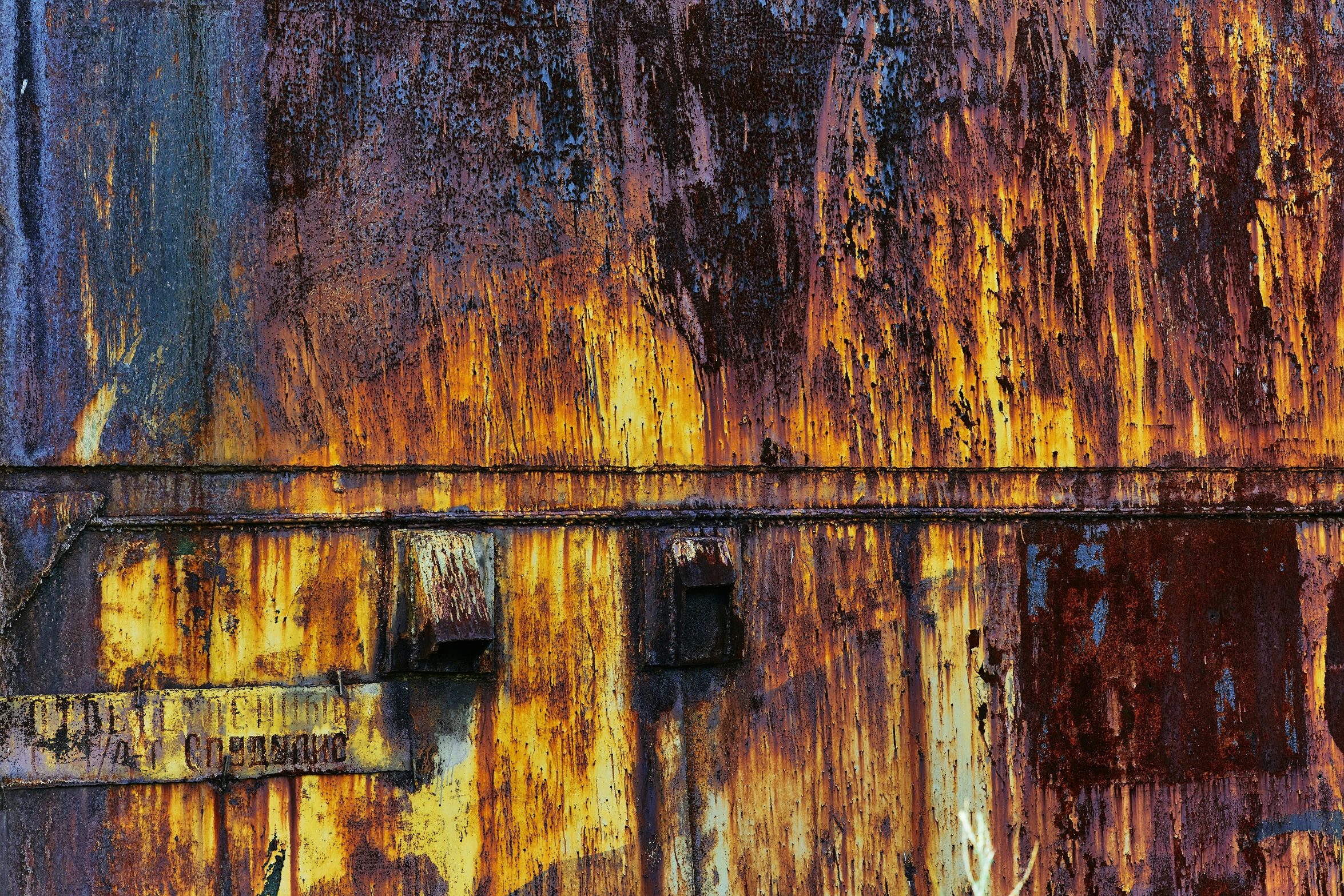 a rusted wall with many holes and stains