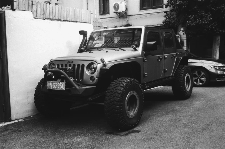 two jeeps parked near a building and trees