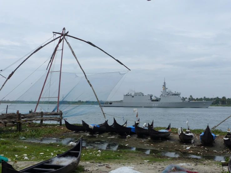 a couple of boats sitting on the shore next to a boat