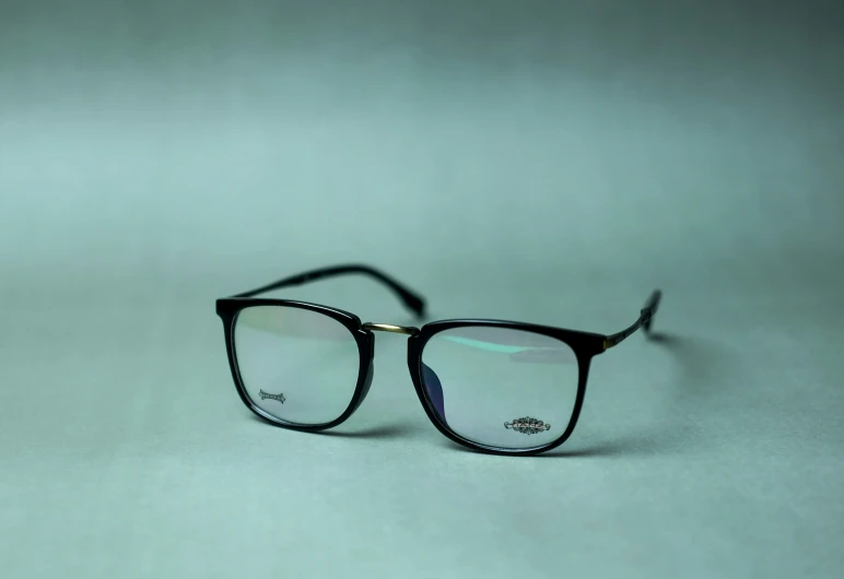 a pair of black and silver eyeglasses on grey background