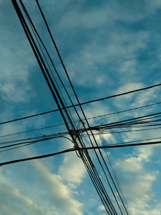 an electric pole and telephone poles in the blue sky