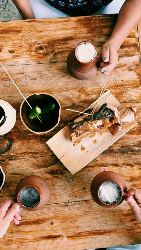 people eating some food on a wooden table