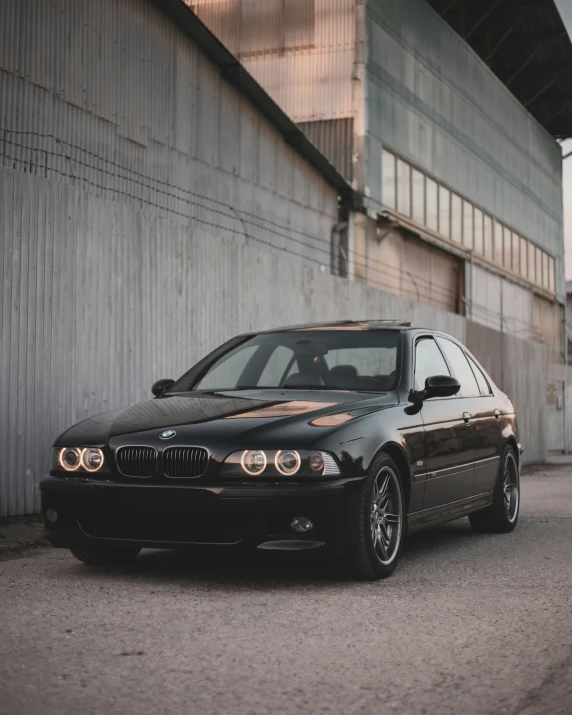 a black car parked in front of a grey building