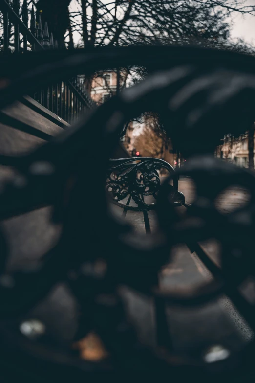 a bicycle parked on the road through a metal fence