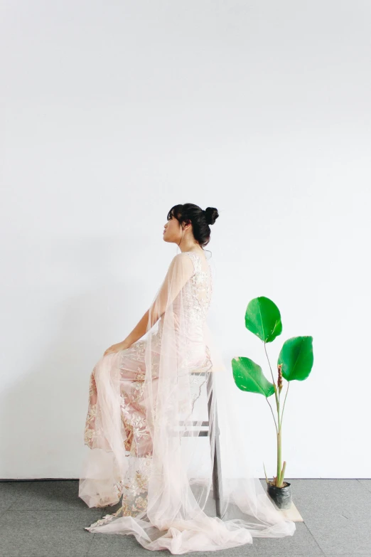 a woman sitting down with a sheer dress over her shoulder