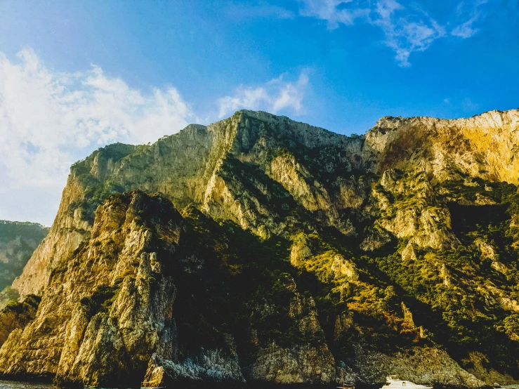 a couple people are sitting on a boat by the rocks