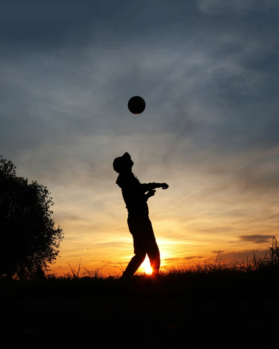 a man is throwing a ball to the sky