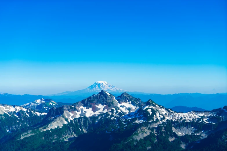 a very tall mountain sitting over snow covered hills