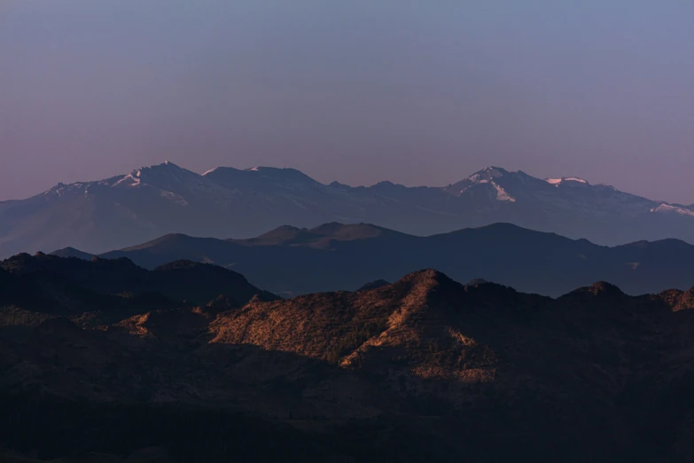 the tops of the mountains have a hazy sky above them