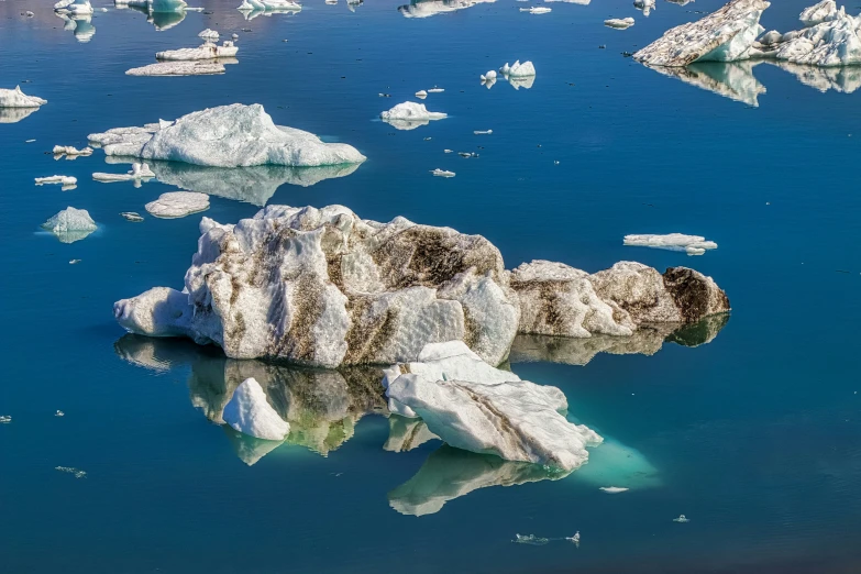 some ice is floating on the water near some ice floes