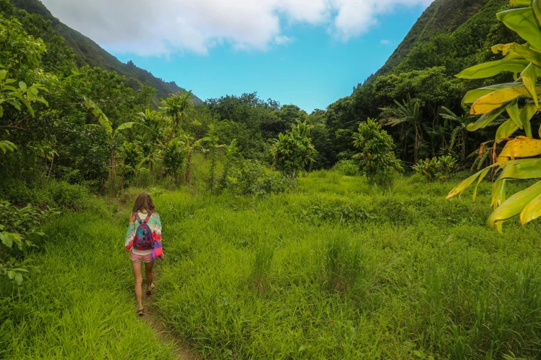 a woman hiking down a trail in the jungle