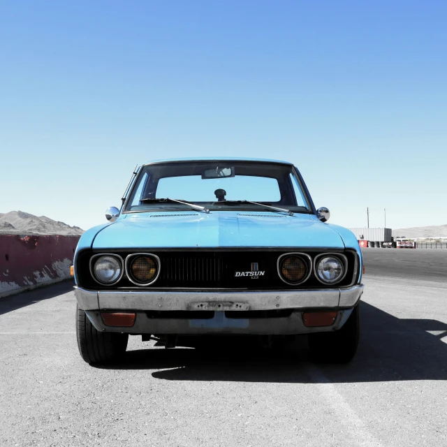 a blue sports car is parked in the desert