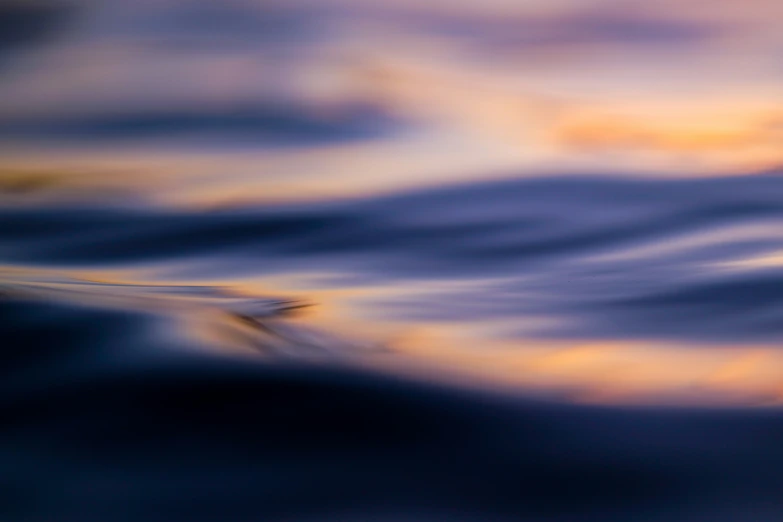 there is a blurry image of a wave on the water