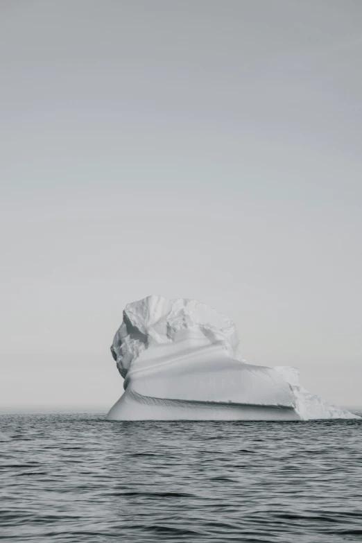 a iceberg floats through the ocean on a clear day