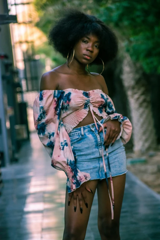 an african american woman wearing torn off shoulder top