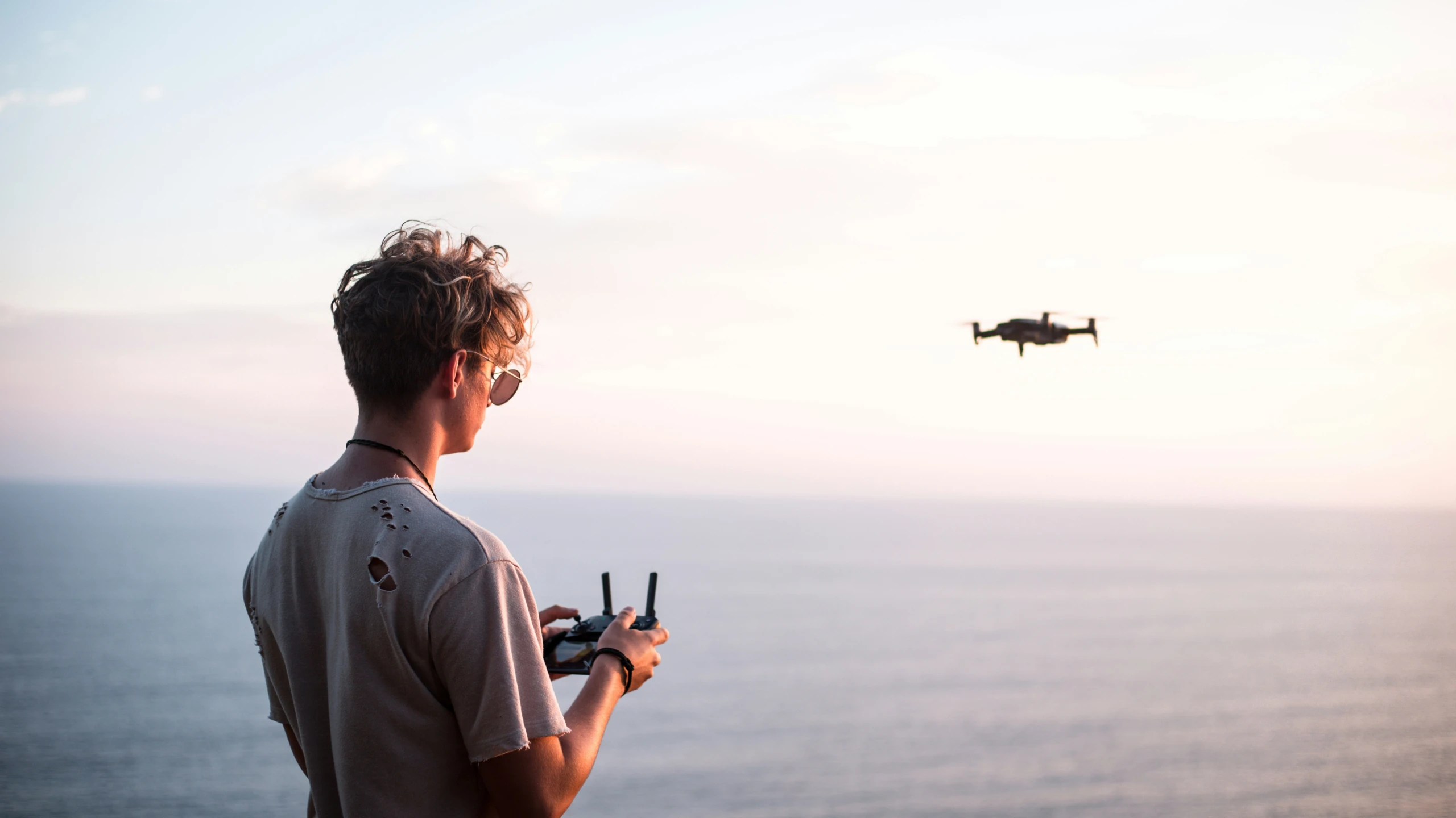 the man is taking pictures with his phone of an aircraft in the sky