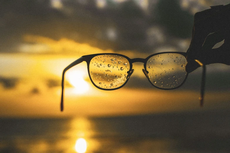 a pair of glasses hanging off a string that has drops of water on it