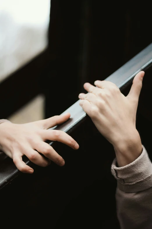 someone holding their hands out over a railing