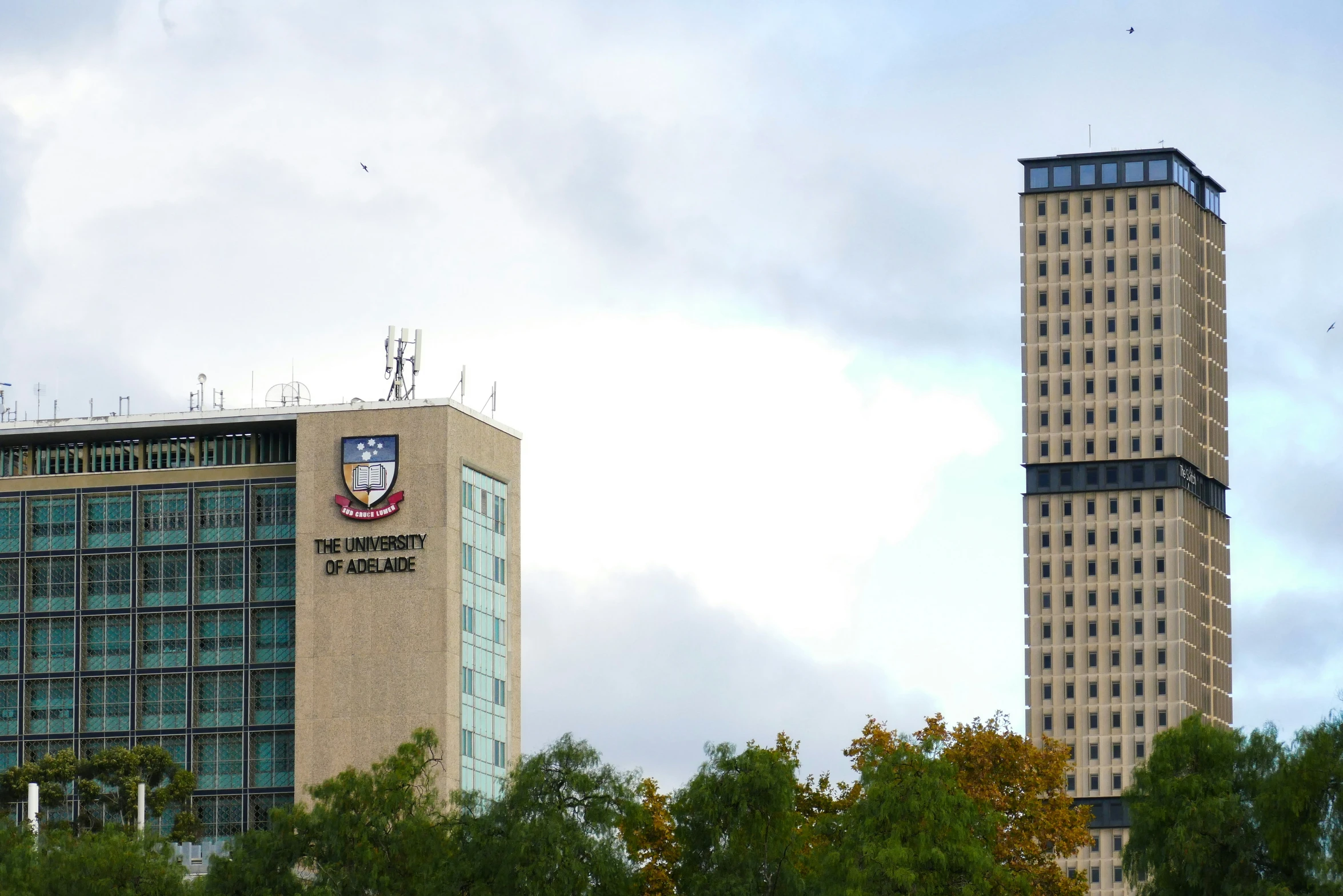 two large buildings stand next to each other under clouds