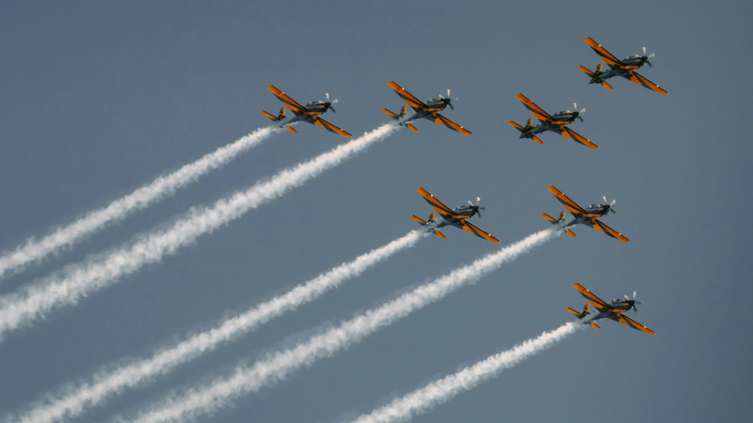 nine airplanes in the sky with vapor trails