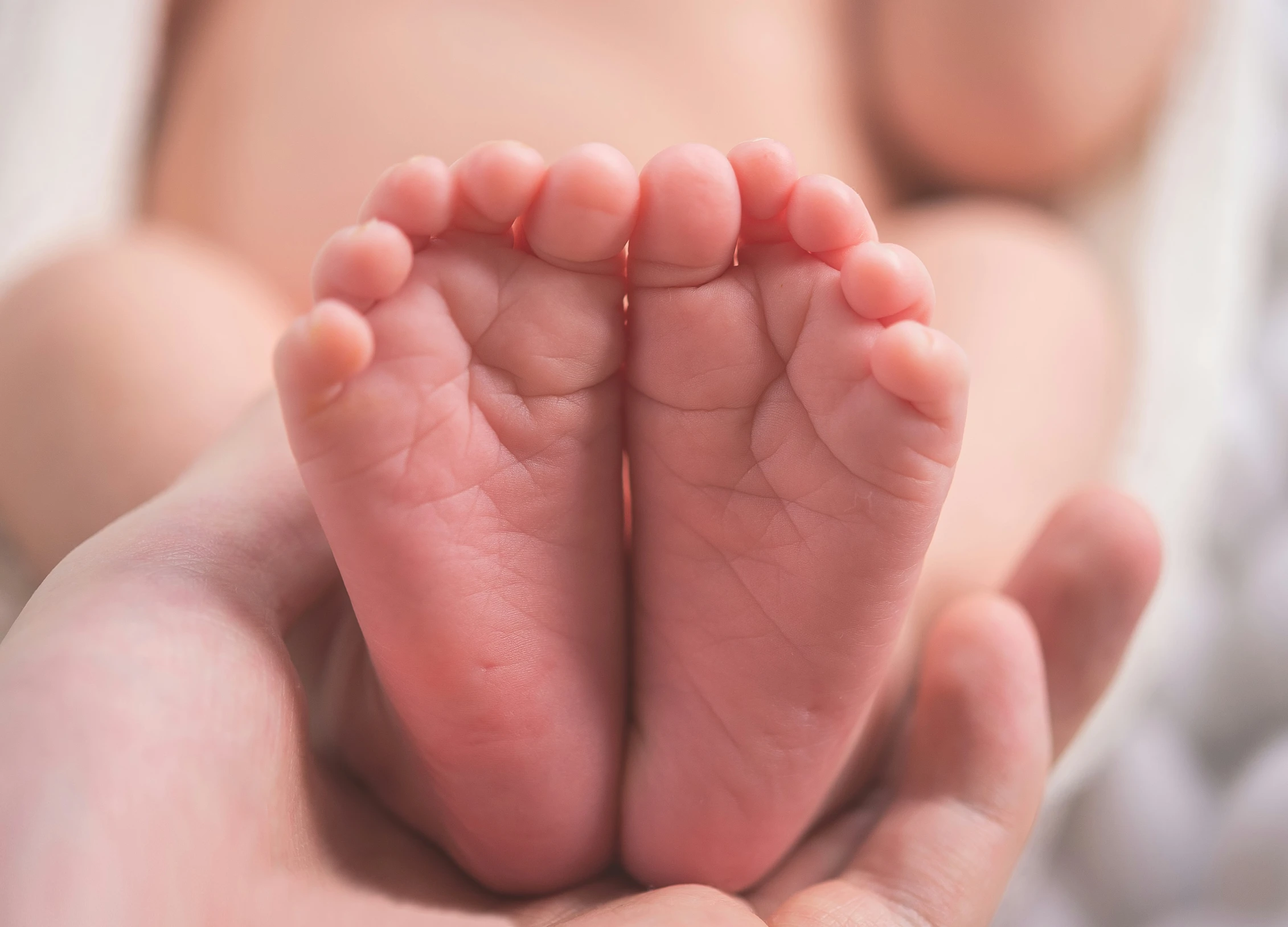 a person holding a small baby's foot in their hands