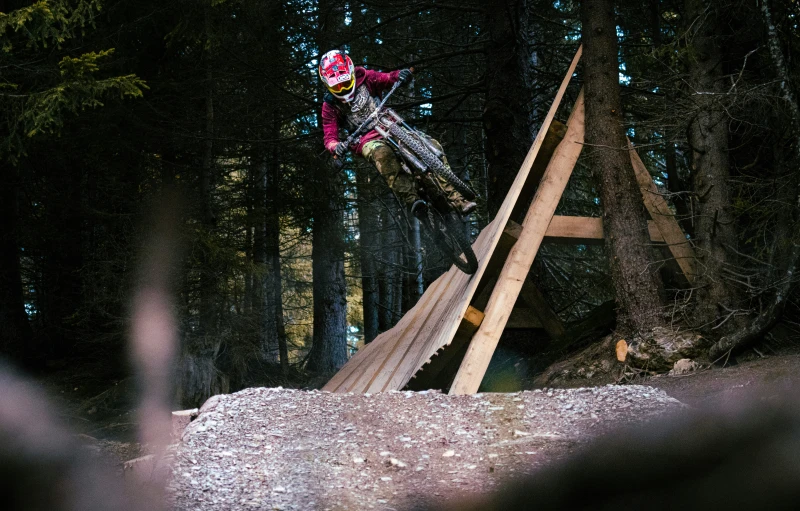 a person doing a jump on a bicycle in the woods