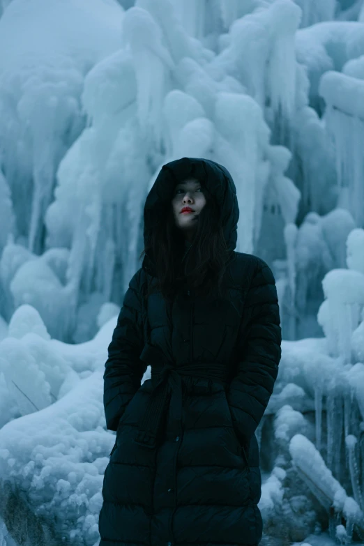 a woman standing next to ice covered trees