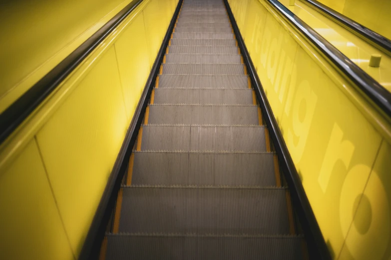 escalators for moving down a yellow walkway