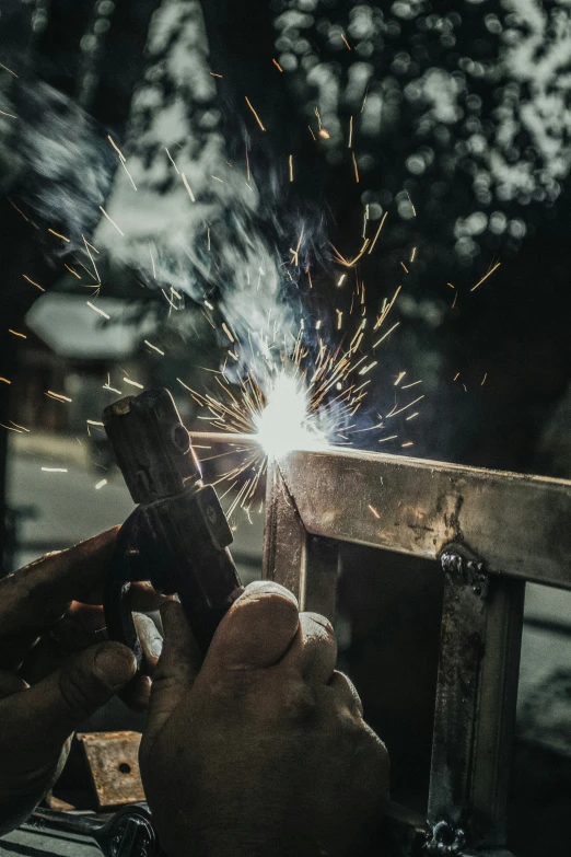 an adult uses a smartphone on a work bench