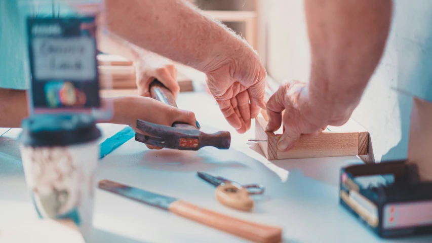 people are holding hands over an object on a table