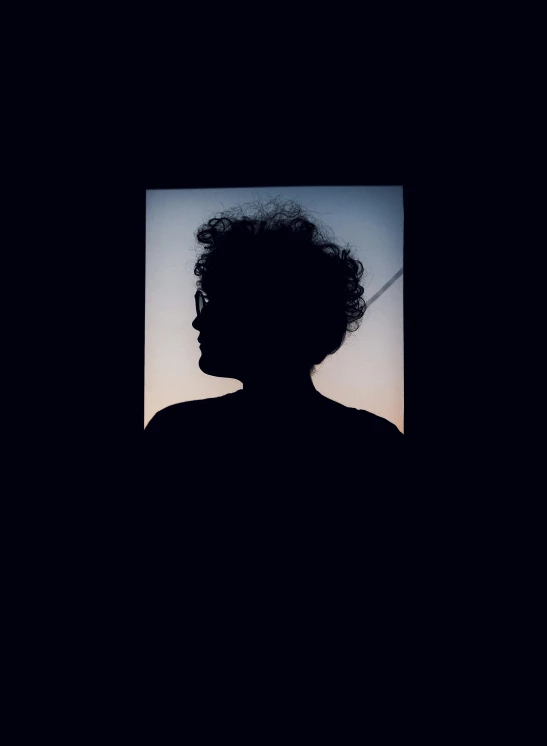 the silhouette of a person in a dark room