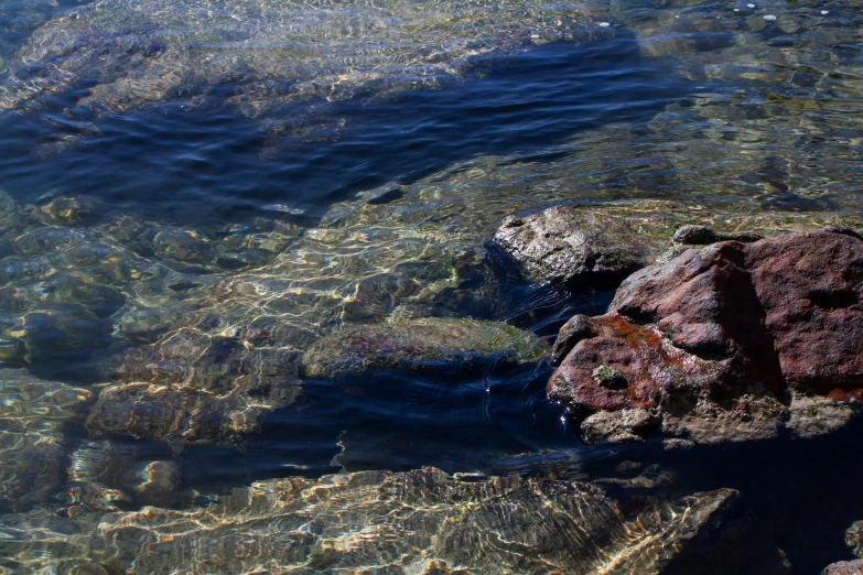 a view of rocks in the water from above