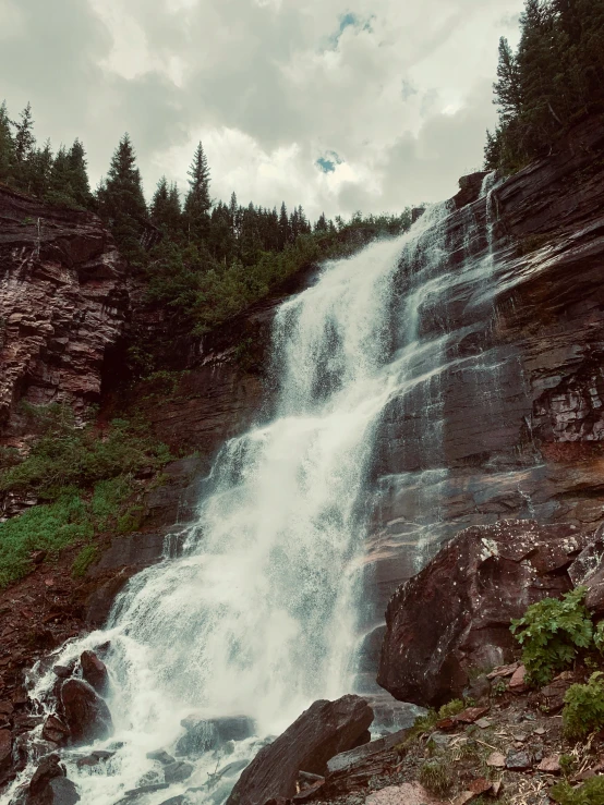 a large waterfall in the middle of a forest