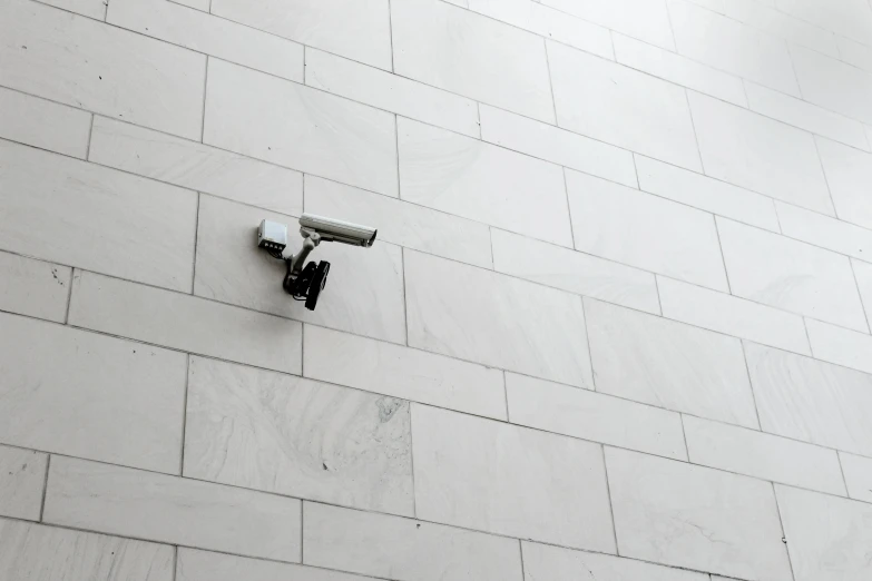 a white security camera on the side of a building