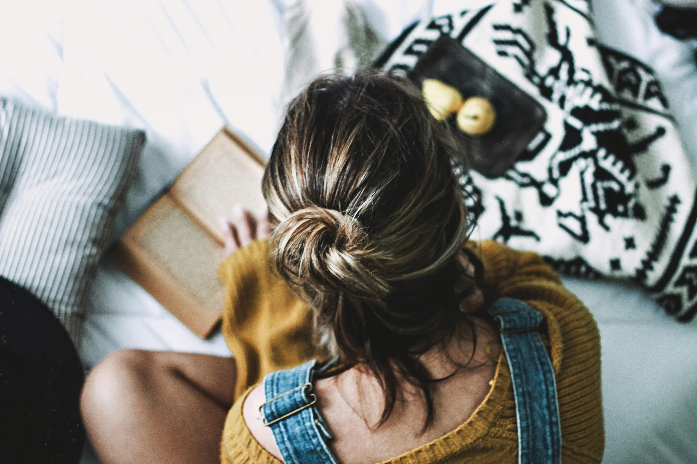 a person sitting down on a couch reading a book