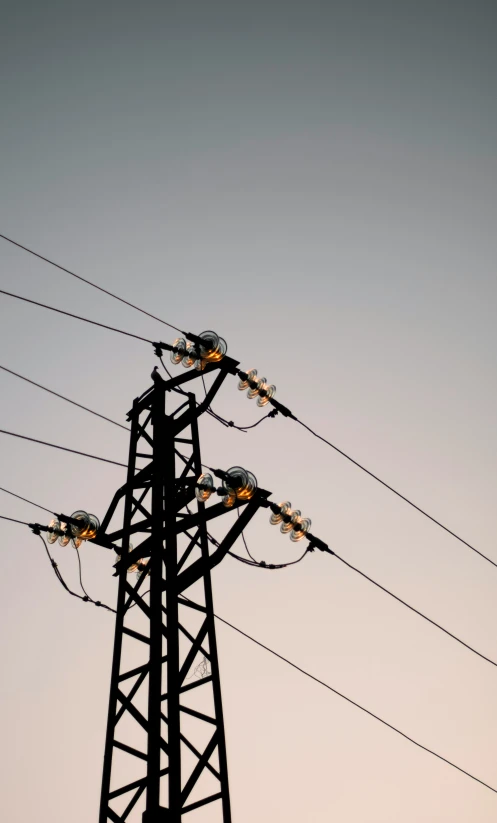 a black power pole with a sky in the background