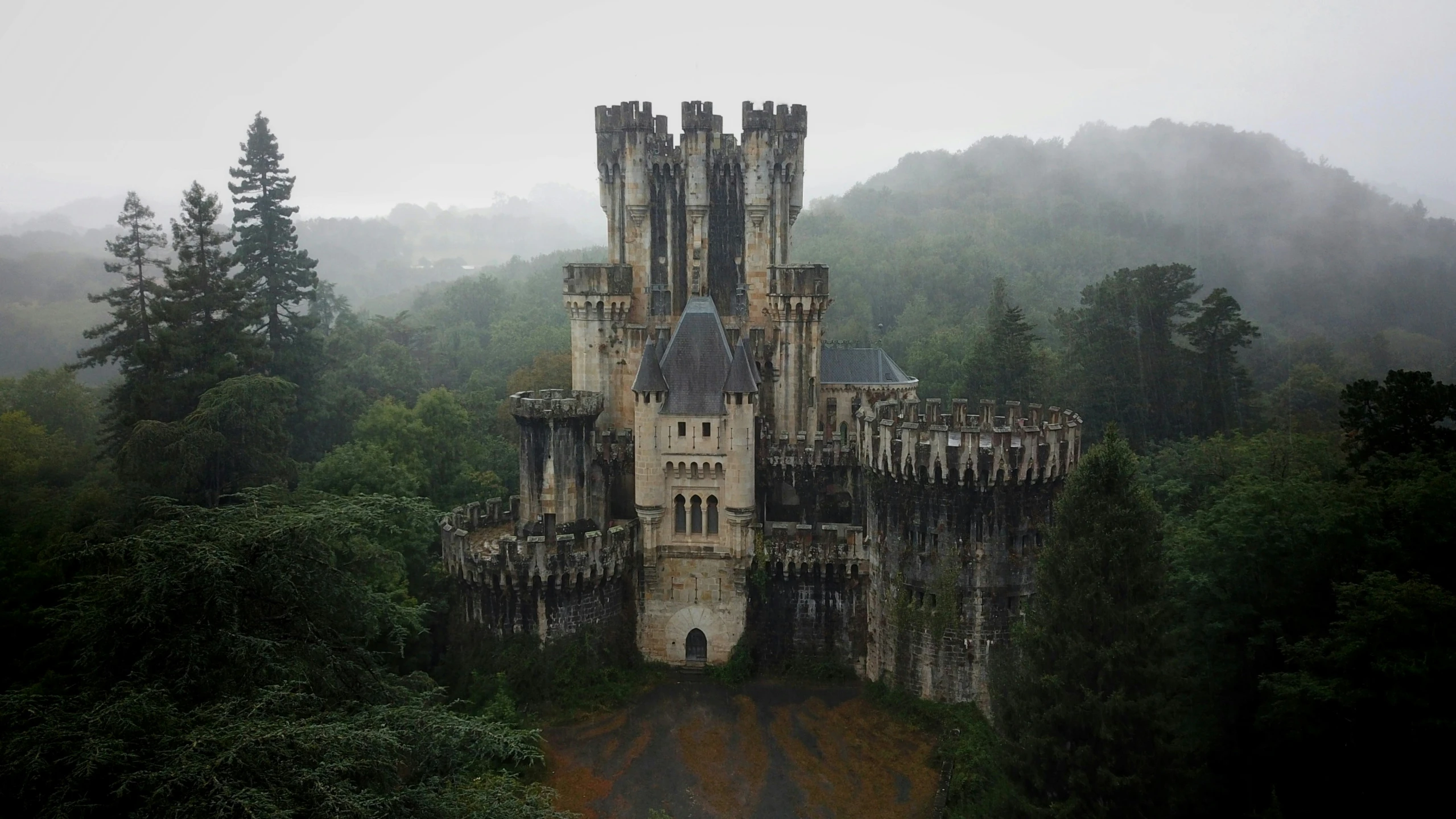 a castle surrounded by trees in the middle of nowhere