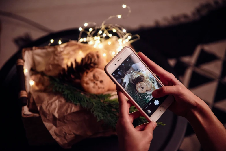 a person holding a phone near a large arrangement of food